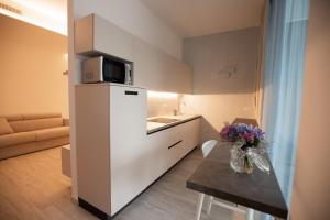 a small kitchen with a white refrigerator and a table at Marigold Residence in Roseto degli Abruzzi