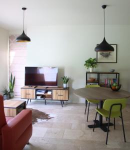 a living room with a table and a tv at Holiday Apartment Al 't Sanna in Geraardsbergen