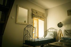 a room with a bed and a mirror and a window at Les Gîtes du Gouélou in Callac