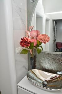 a vase with flowers on a counter next to a mirror at Royal 2 **** in Slavonski Brod +24 photos