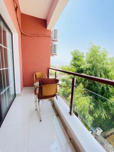 a balcony with chairs and a view of trees at JANO HOUSE AppartHôtel in Djibouti