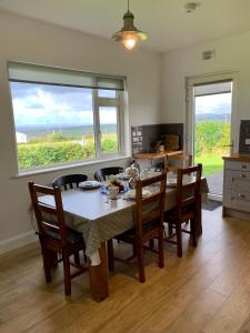 a dining room with a table and chairs and a window at Doolin View Apartment in Doolin