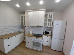 スィクティフカルにあるComfort Apartmentsのキッチン(白いキャビネット、白い冷蔵庫付)