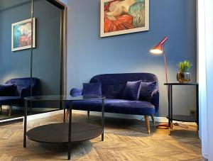 a living room with a blue couch and a glass table at Hotel Rumor in Budapest