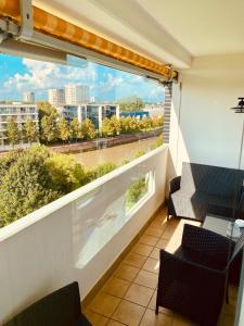 einen Balkon mit 2 Stühlen und Stadtblick in der Unterkunft COAST HOUSE Dünenloft in Bremerhaven