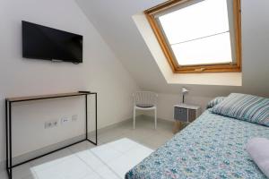 a bedroom with a bed and a tv on the wall at Nautilus Atico, 3 dormitorios, puerto, by Bookindenia in Denia