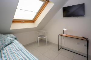 a bedroom with a bed and a tv and a chair at Nautilus Atico, 3 dormitorios, puerto, by Bookindenia in Denia