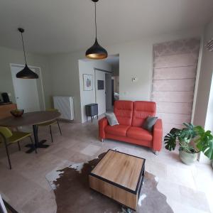 a living room with a red couch and a table at Holiday Apartment Al 't Sanna in Geraardsbergen