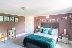 a bedroom with a bed and a pink wall at Spacious split level flat in great location in Portsmouth