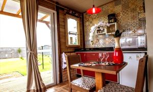 a kitchen with a table with wine glasses on it at Cabanas do Rosa in Praia do Rosa