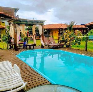 a large blue swimming pool on a wooden deck at Cabanas do Rosa in Praia do Rosa