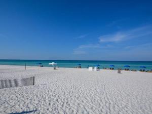- une plage avec des chaises et des parasols et l'océan dans l'établissement Largo Mar, à Panama City Beach