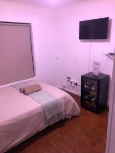 um quarto com uma cama e uma televisão de ecrã plano em Luxury Suites at St Petes Duplex Townhouse em Newton Park