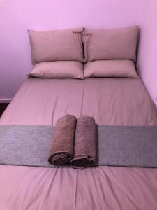 a bed with two pillows and two towels on it at Luxury Suites at St Petes Duplex Townhouse in Newton Park