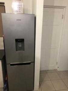 um frigorífico com um dispensador de água numa cozinha em Luxury Suites at St Petes Duplex Townhouse em Newton Park