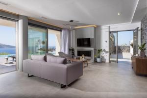 uma sala de estar com um sofá e uma mesa em Rock Bay Villas - Luxury Villas in Crete em Agia Pelagia