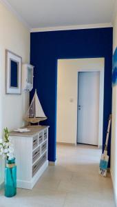 ein Wohnzimmer mit einer blauen Wand und einer Tür in der Unterkunft COAST HOUSE Dünenloft in Bremerhaven