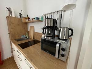 eine Küche mit einer Spüle und einer Mikrowelle in der Unterkunft LE-Citywohnung-I in Leipzig