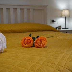 duas rosas laranjas em cima de uma cama em La Terrazza Azzurra em Bellisio di Sopra