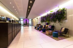 a lobby with a hair salon with purple flowers at Lindner Hotel Berlin Ku'damm, part of JdV by Hyatt in Berlin