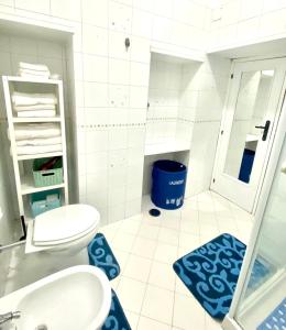 a bathroom with a toilet and a sink with blue rugs at Casa Luisa in Naples