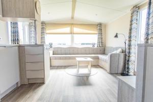 a living room with a couch and a table at Chalet 536 op Recreatiepark De Wielen in Sint Maarten