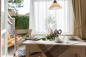 einen Tisch mit Teezubehör und einem Fenster in der Unterkunft Haus am Park Wohnung Nr3 in Spiekeroog