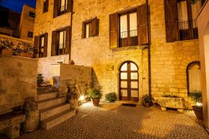 - un vieux bâtiment en pierre avec une porte et des escaliers dans l'établissement Hotel Residenza Petra, à Petralia Soprana