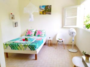 1 dormitorio con 1 cama y ventilador en Studio Goyave en Ducos