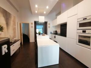 a kitchen with white cabinets and a white counter top at Brugmann Loft Apartment in Brussels