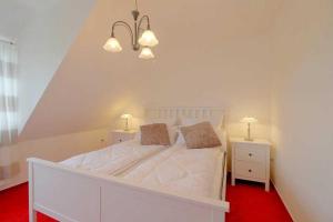 een slaapkamer met een wit bed en 2 nachtkastjes bij MU32a Dachgeschoss in Dorum Neufeld
