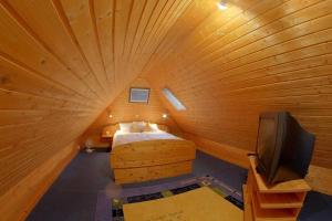 een kamer met een bed en een tv in een houten kamer bij MU32a Dachgeschoss in Dorum Neufeld