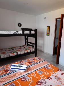 Hostal Casa Mathias في كارتاهينا دي اندياس: غرفة نوم مع سريرين بطابقين وسجادة على الأرض