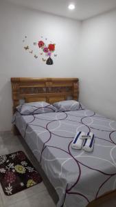 a bedroom with a bed with a flower clock on the wall at Hostal Casa Mathias in Cartagena de Indias