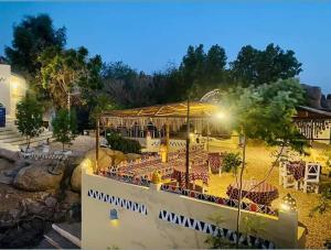 a restaurant with tables and chairs at night at Old Nubian guest house in Aswan