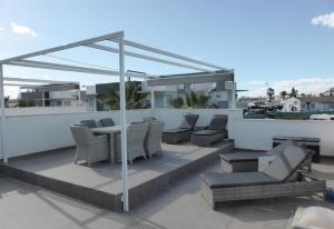 eine Terrasse mit einem Tisch und Stühlen auf dem Dach in der Unterkunft A modern villa with a large solari in Rojales