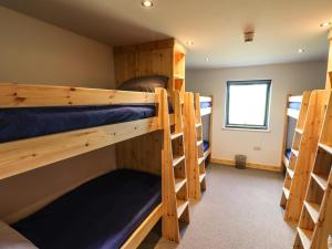 a room with four bunk beds and a window at Dale's Lodge in Carnforth
