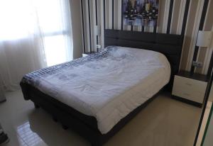 ein großes Bett in einem Schlafzimmer mit Fenster in der Unterkunft A modern villa with a large solari in Rojales