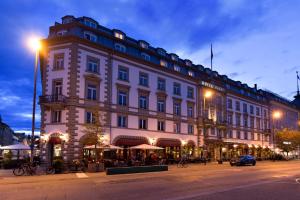 un gran edificio blanco en una calle de la ciudad por la noche en Hotel Halm Konstanz, en Constanza