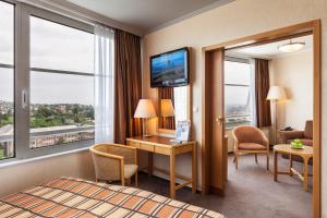 a hotel room with a bed and a desk and window at Hotel Budapest in Budapest