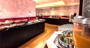 a buffet line with pastries and drinks in a restaurant at Hotel Halm Konstanz in Konstanz