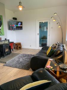 sala de estar con sofá y TV en Doolin View Apartment en Doolin