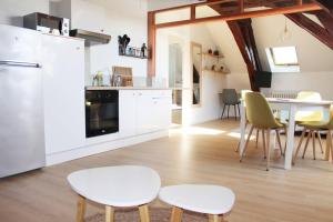 een keuken met witte kasten en een tafel en stoelen bij Cocon plein centre ville - parking privé in Auxerre