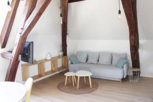 een woonkamer met een bank en 2 tafels bij Cocon plein centre ville - parking privé in Auxerre