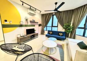 a living room with a couch and chairs and a tv at KL Gateway Premium Residences by Moka in Kuala Lumpur