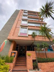 ein Gebäude mit Palmen davor in der Unterkunft Hotel 104 Art Suites in Bogotá
