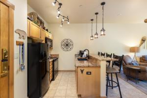 a kitchen with a black refrigerator and a counter at 8115 Arapahoe Lodge condo in Keystone