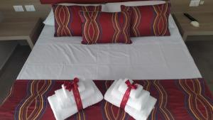 ナポリにあるRegina Margherita Suiteのベッド(白いタオル、赤い弓付)