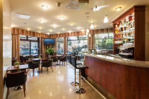 a restaurant with a bar with tables and chairs at Hotel Budapest in Budapest