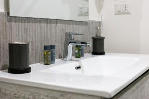 a bathroom sink with a faucet and a mirror at Mamì B&B in Naples +61 photos